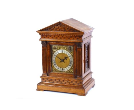 A late Victorian oak chiming bracket clock, the temple case enclosing a brass spandrel dial with steel chapter rings, strikin