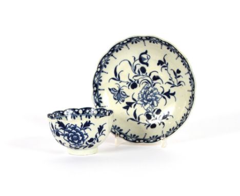A Worcester blue and white tea bowl and saucer, decorated foliage and butterflies, crescent mark to base