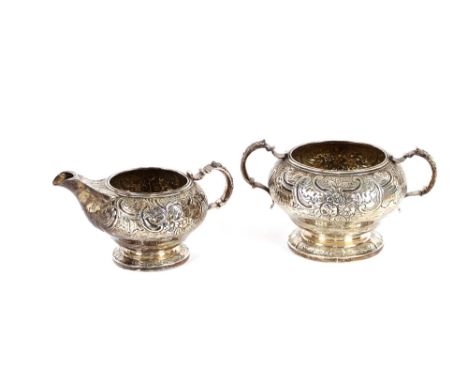 A George III silver cream jug and sucrier, having rich foliate embossed decoration and cartouche scrolls, London 1815, 17ozs.