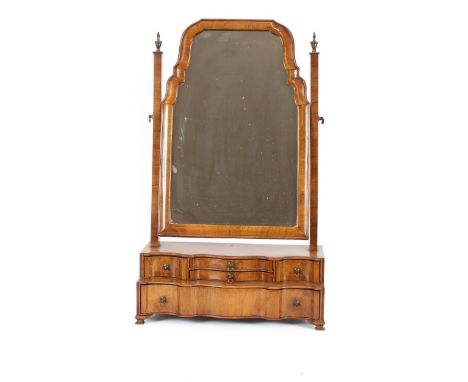 An 18th Century style walnut swing toilet mirror, the shaped plate raised above a serpentine stepped base, fitted various dra