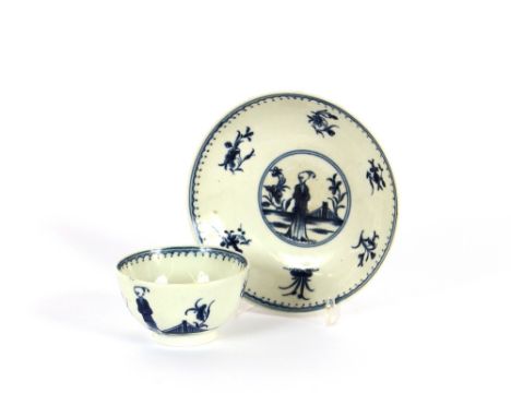 A Worcester tea bowl and saucer, decorated with a china-man figure and floral sprigs, under-glazed blue crescent mark to base