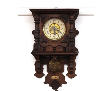 A late Victorian walnut cased wall clock, having leaf carved decoration to the case, circular dial within turned half columns