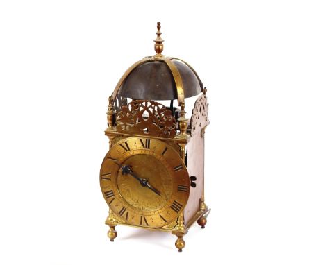 An 18th Century brass lantern clock, the bell surmounted by an urn finial above pierced sides, Roman numeral chapter ring, fo