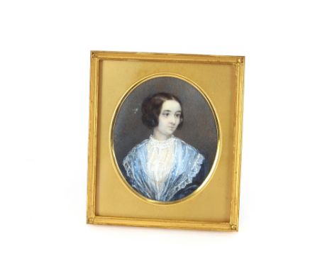 A miniature portrait on ivory, depicting a lady in blue lace trimmed dress, contained in a brass easel frame