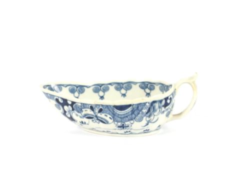 An 18th Century blue and white porcelain oval cream boat,&nbsp;decorated in the Chinese manner of fluted form, scroll handle 
