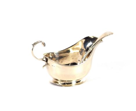 A silver cream jug, London 1915; and a silver sauce ladle, Birmingham 1921, (2)