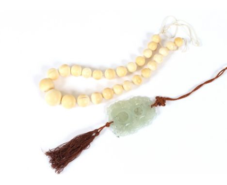 A Chinese jade pendant, of pierced design; and a set of graduated ivory beads, (2)