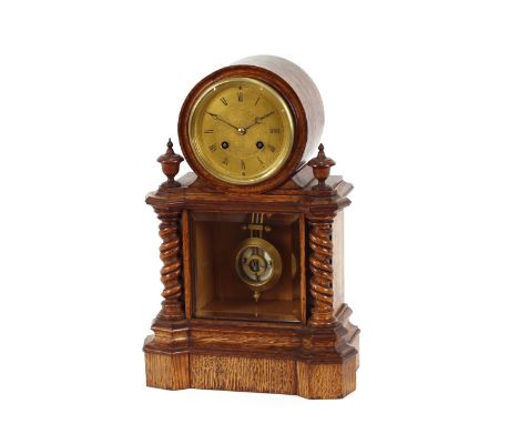 A late Victorian golden oak cased mantel clock,&nbsp;having circular engraved brass Roman numeral dial, and eight day movemen