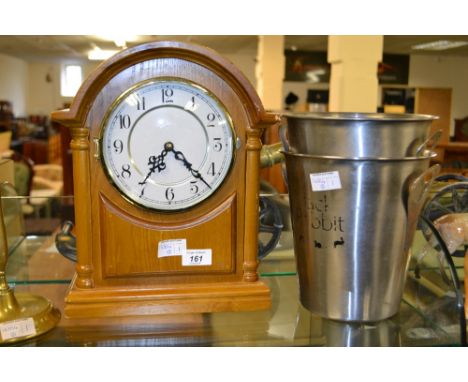 Two stainless steel ice buckets, together with a modern mantle clock and a brass candle stick 