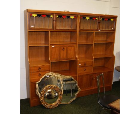 Two vintage teak book cases, each having cupboards and drawers and stained glass panels. 