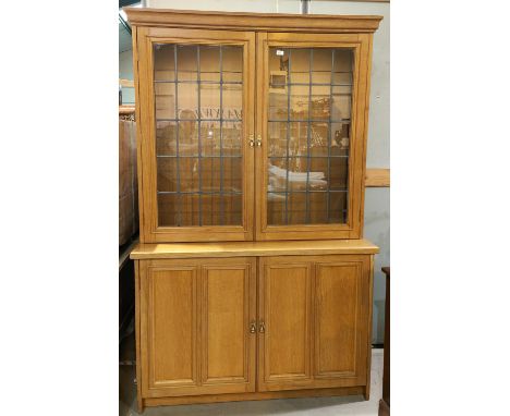 A light oak full height bookcase with 2 leaded glass doors over 2 panelled doors, ht. 210cm 