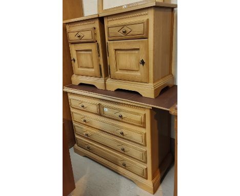 A modern light chest of 2 long and 2 short drawers and a pair of matching bedside cabinets and wall mirror