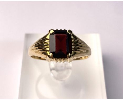 An 18 carat hallmarked gold gent's ring set large cushion cut garnet coloured stone. 6gm, size W/X 