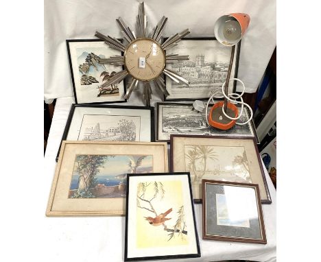 A vintage sunburst wall clock; a vintage lamp and prints. 