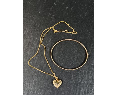 A yellow metal bangle with chevron decoration stamped 375, 4gm; a yellow metal heart pendant stamped 375 on fine gold chain s