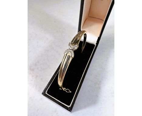A 9 carat hallmarked gold hinged bangle set with small diamond in reversed demi lune setting, 8gm 