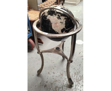 A modern terrestrial globe in black and white finish on gimble and stainless steel stand 