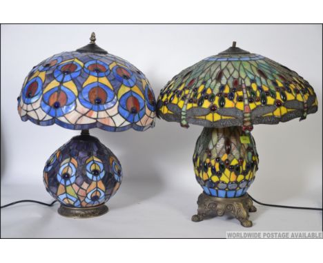 A Tiffany style glass lamp and shade having a dragon fly design along with another of similar form. Measures: 58cms high.