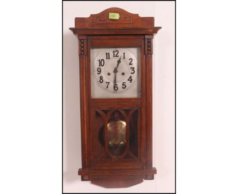 A 20th century oak cased silvered dial eight day movement wall clock with pendulum and glass viewing panel. Measures: 79cms h