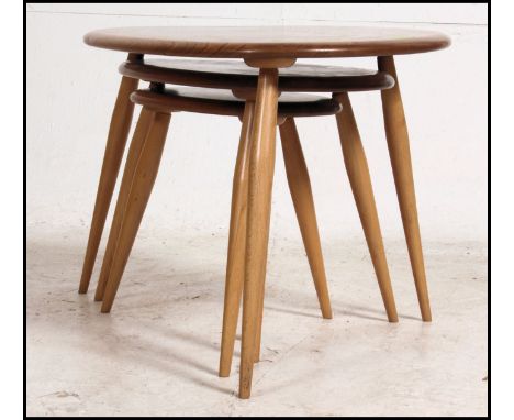 An Ercol beech and elm retro pebble nest of tables. Each raised on turned legs having graduating elm tops to each. Measure: 4