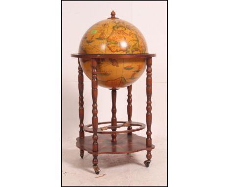 An antique style drinks globe having hinged centre with sectional interior raised on fitted trolley base. Measures: 95cms hig