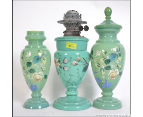 A late 19th century hand painted oil lamp with two matching vases each with hand painted floral design. Measures: 40cms high.