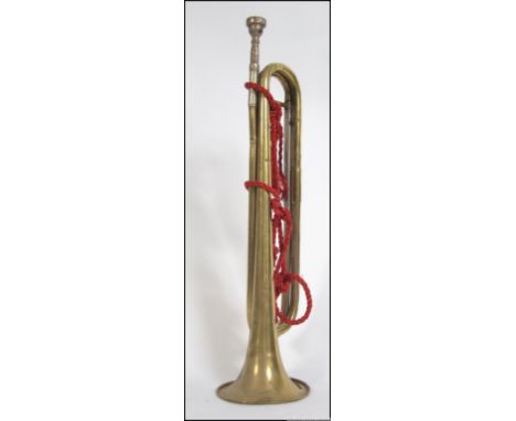 MUSICAL INSTRUMENTS : A vintage Danelle brass bugle with rope ties being marked to the horn.
