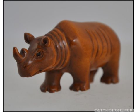 A carved hardwood netsuke in the form of a rhinoceros.   Measures: 6cms long.