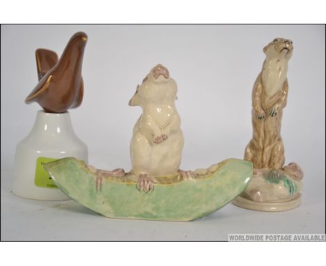 A collection of three ceramic pieces to include a Royal Worcester two piece vent, a continental figure of an otter along with