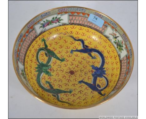 A Chinese famille  / juane rose bowl with decorative yellow panel work, green and blue dragons and geometric panel work elsew