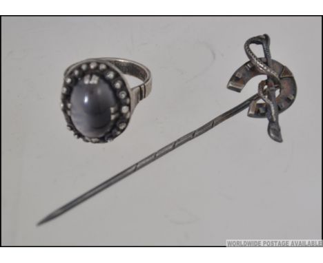 A silver hallmarked stick pin of hunting / horsing interest with horse shoe and riding crop. Together with a 900 silver marke