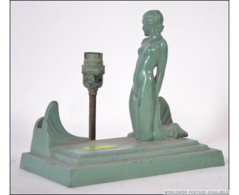 An art deco cast metal figural table lamp in the form of a kneeling nude female on stepped cast base H21cm