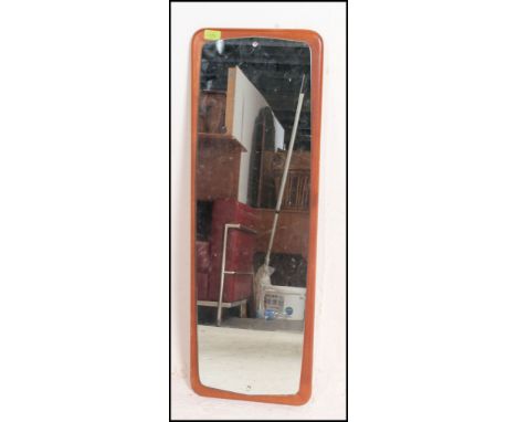 A retro 1970's atomic teak and frameless wall mirror. The teak chamfered edge panel to verso with original makers lable attac