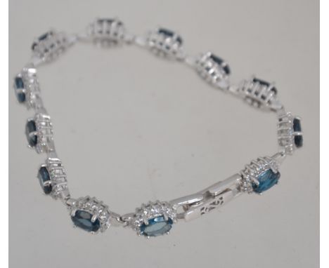 A ladies contemporary silver and London blue topaz bracelet, each stone being claw mounted with linkage. Total weight 14g / /