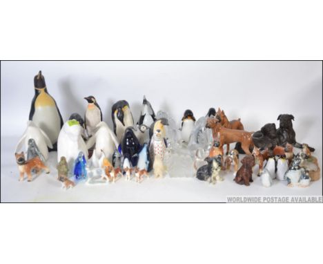 A collection of ceramic and studio glass penguins of various forms to include Bristol blue style, novelty money box etc. alon