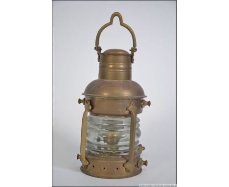 An early 20th century brass ships navigational light with cage protective bars, original glass to lamp. Notation for 'Anchorl