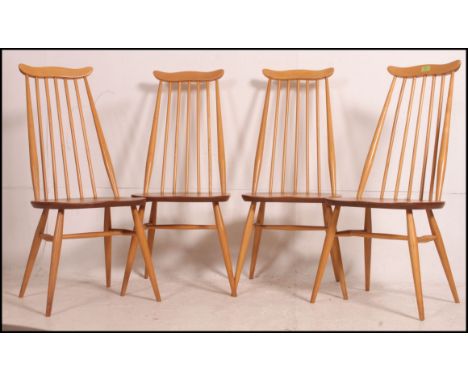 A set of 4 Ercol beech and elm Goldsmiths dining chairs with railed back rests over saddle seats and turned legs. Measure: 98