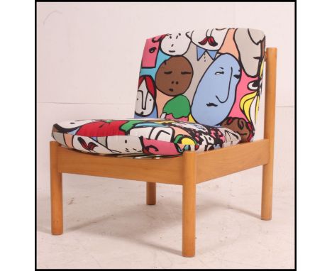 A vintage Ercol 741 lounge chair of beech wood form marked to base having abstract face cushions ( new webbing )