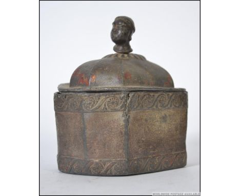 A 19th century  unusual heavy lead casket of octagonal form with tribal head finial, the lid and body with remains of scrollw