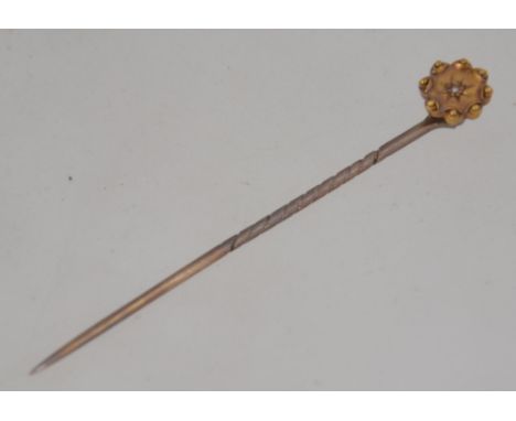 A Victorian 9ct gold and diamond inset stick / hat pin with flower head top. Total weight 1.8g