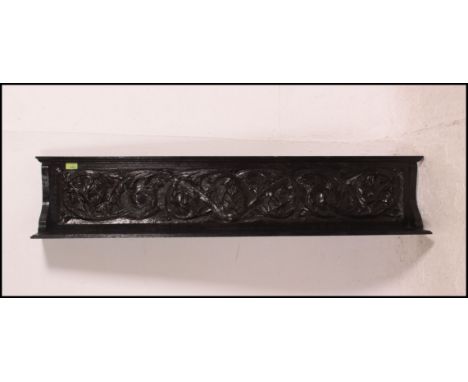 A 19th century ebonised oak carved wall bracket, incorporating a frieze panel with carved floral decoration. Measures: 26cms 
