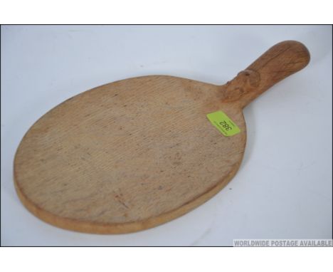 A Robert Mouseman Thompson oval bread board, with mouse carved to the handle. Measures: 38cms long