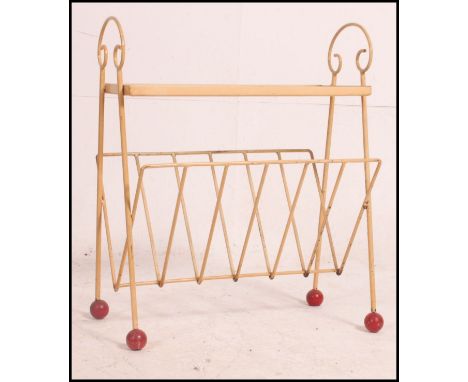 A mid century wire work painted magazine rack / canterbury having red finials with the top having inset safety mesh glass pan