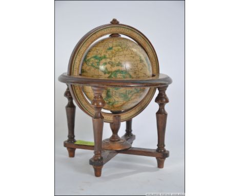 A 19th century style terrestrial library globe set within a wooden gimble frame, Measures: 27cms high.