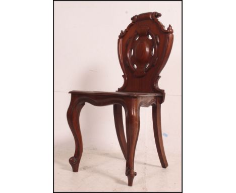 A Victorian solid mahogany hall chair with armorial carved back rest over panel seat and turned legs. Measures: 90cms high x 