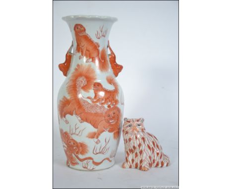 An early 20th century Chinese ceramic figurine of a ginger tom cat bearing red character marks to the base. Together with a C