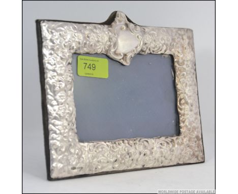 A silver hallmarked easel back picture frame having floral decoration in repose having London assay marks and makers mark WW 