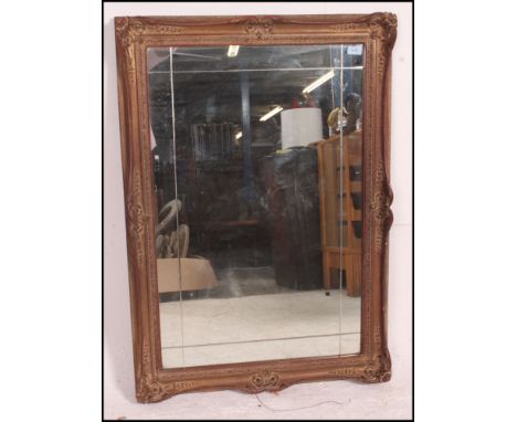 A large 19th century gesso moulded gilt framed wall hanging mirror having ornate moulding with central mirror panel  and back