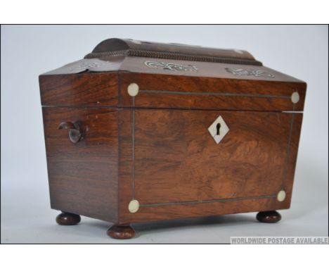 A Regency rosewood tea caddy, early 19th century, of sarcophagus form, with  mother of pearl inlay and twin lidded interior. 