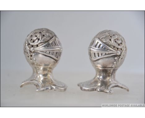 A Victorian style  silver plated pair of  novelty pepper pots in the form of a knights helmet marks to the base for Mappin & 